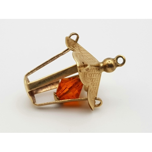 1088 - 9K YELLOW GOLD LANTERN CHARM WITH MOVING ORANGE STONE SET AS A LIGHT BULB, 1G