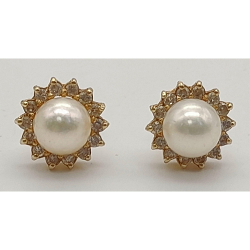 933 - A PAIR OF PEARL STUD EARRINGS SET IN 14K YELLOW GOLD. 2.6gms