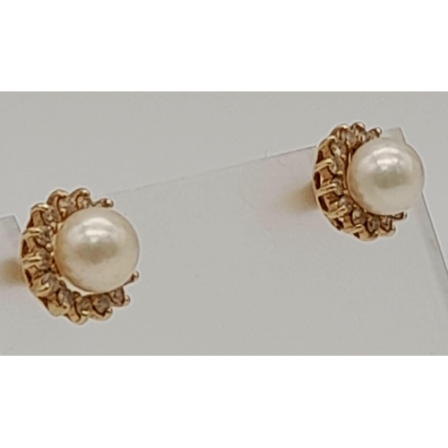 933 - A PAIR OF PEARL STUD EARRINGS SET IN 14K YELLOW GOLD. 2.6gms