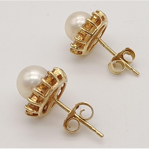 933 - A PAIR OF PEARL STUD EARRINGS SET IN 14K YELLOW GOLD. 2.6gms