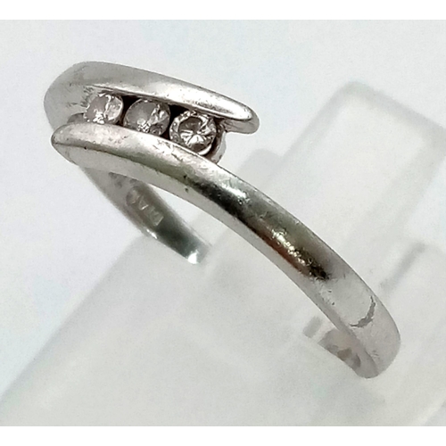 785 - A PLATINUM 3 DIAMOND CROSSOVER RING.  2.9gms   size N