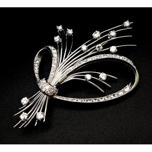 16 - An 18K White Gold and Diamond Brooch. A Beautiful bow of white gold and diamonds containing a bushel... 