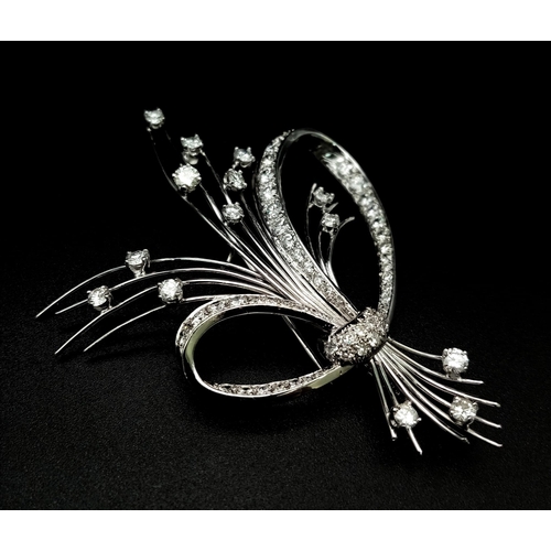 16 - An 18K White Gold and Diamond Brooch. A Beautiful bow of white gold and diamonds containing a bushel... 