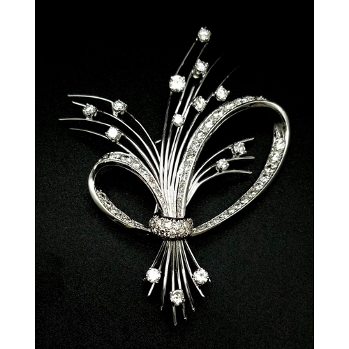 16 - An 18K White Gold and Diamond Brooch. A Beautiful bow of white gold and diamonds containing a bushel... 