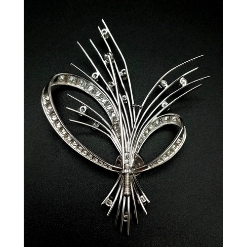 16 - An 18K White Gold and Diamond Brooch. A Beautiful bow of white gold and diamonds containing a bushel... 