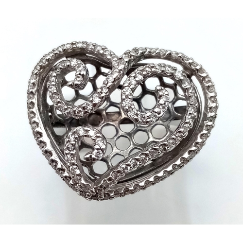 1089 - An 18 K white gold ring with a diamond encrusted heart on top.  Size: N1/2, weight: 5.34 g.