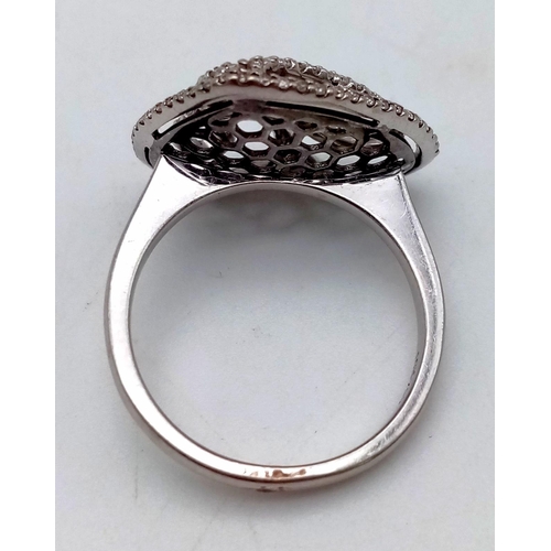 1089 - An 18 K white gold ring with a diamond encrusted heart on top.  Size: N1/2, weight: 5.34 g.