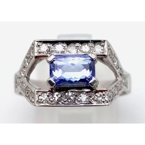 402 - An ART DECO 18 k white gold ring with a rectangular tanzanite and numerous diamonds. Size: P, weight... 