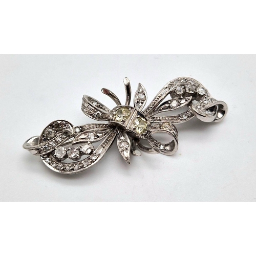 260 - A beautiful 18 K white gold brooch with diamonds and two yellow brilliant cut diamonds at the centre... 