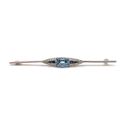 649 - An ART DECO 18 K white gold brooch with a rectangular aquamarine, emeralds and blue sapphires, surro... 