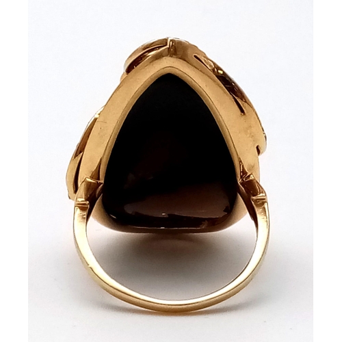 745 - An 18 K yellow gold ring with diamond encrusted bands resting on a large smoky quartz cabochon. Ring... 