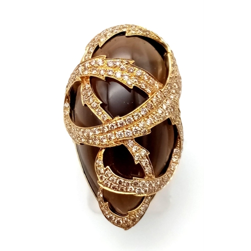 745 - An 18 K yellow gold ring with diamond encrusted bands resting on a large smoky quartz cabochon. Ring... 