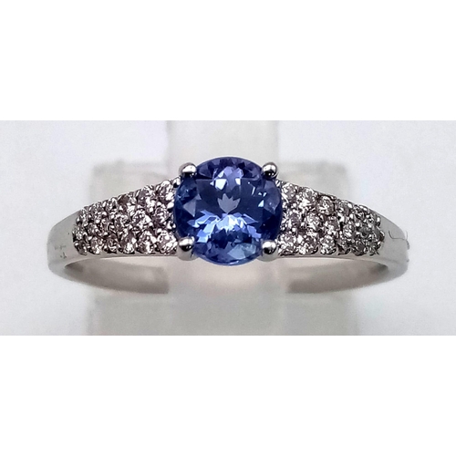 780 - A 14 K white gold ring with a central round cut tanzanite (0.66 carats) and diamonds (0.17 carats) o... 