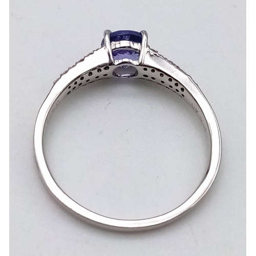 780 - A 14 K white gold ring with a central round cut tanzanite (0.66 carats) and diamonds (0.17 carats) o... 