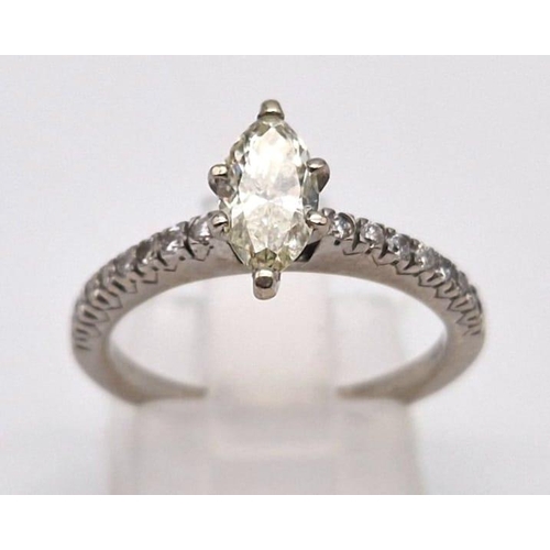 911 - A 14 k white gold ring with a central marquis cut diamond with yellow hues and 16 further diamonds o... 