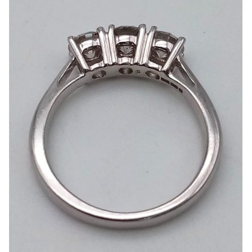 919 - An 18 K white gold ring with a trilogy of brilliant cut diamonds.  Size: M, weight: 4.3 g.