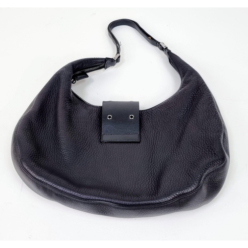 331 - A Christian Dior Street-Chic Hobo Bag in Black Grained Leather. Silver-toned hardware. Dior monogram... 