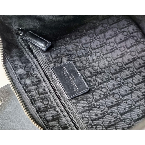 331 - A Christian Dior Street-Chic Hobo Bag in Black Grained Leather. Silver-toned hardware. Dior monogram... 