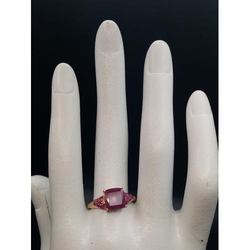 229 - A 9K Yellow Gold Ruby Ring. Central square-cut ruby with six smaller rubies either side. size P. 2.5... 