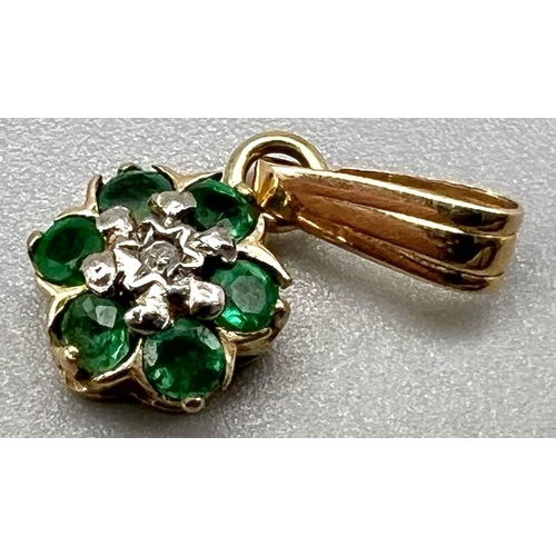 1006 - A 9 K yellow gold pendant with a central diamond surrounded by emeralds. weight: 0.5 g.