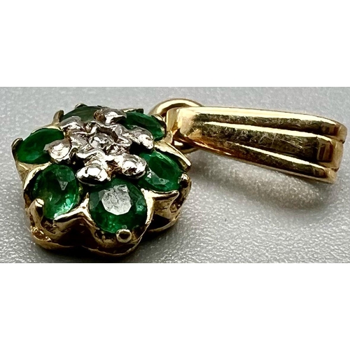 1006 - A 9 K yellow gold pendant with a central diamond surrounded by emeralds. weight: 0.5 g.