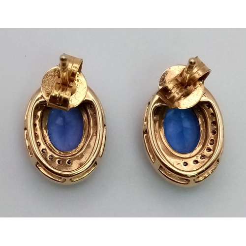 116 - A beautiful, 18 k yellow gold pair of earrings with an oval cut tanzanite surrounded by a halo of di... 