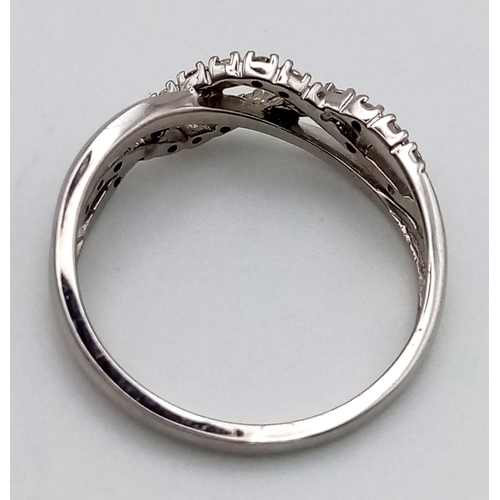 704 - A 9 k white gold ring with twisted diamond bands on top. Size: N, weight: 2.2 g.