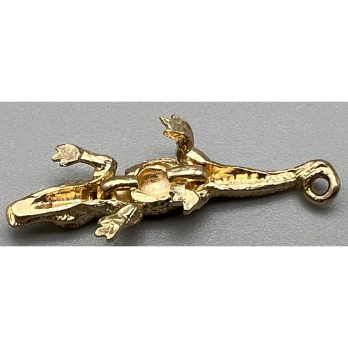 754 - A 9 K yellow gold, very detailed and articulate crocodile 
 charm. Length: 28 mm, weight: 1.6 g.