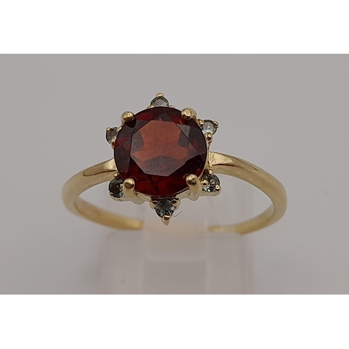 90 - An Antique 9k Yellow Gold Red and Green Garnet Ring. Central blood red garnet with a halo of six sma... 