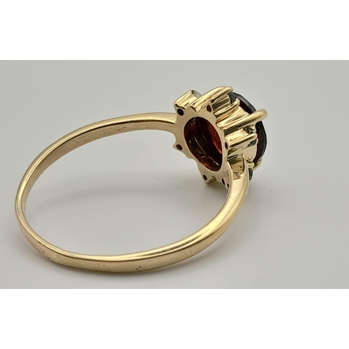 90 - An Antique 9k Yellow Gold Red and Green Garnet Ring. Central blood red garnet with a halo of six sma... 