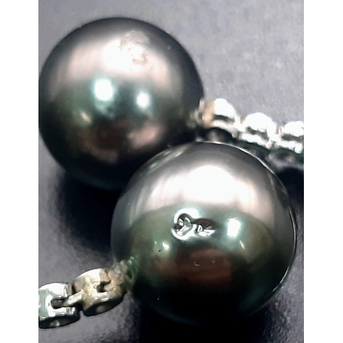 134 - An 18 K white gold pair of earrings with diamonds and Tahitian grey pearls. Drop: 25 mm, total weigh... 