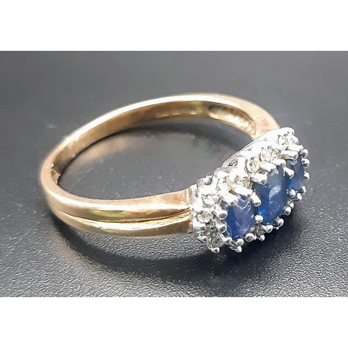 240 - A 9 K yellow gold ring with a trilogy of blue sapphires surrounded by diamonds (0.15 carats). Size: ... 