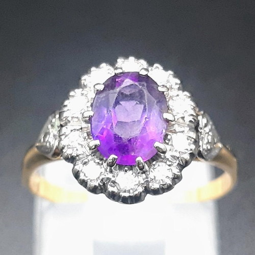 388 - An 18 K yellow gold ring with a central amethyst surrounded by diamonds.