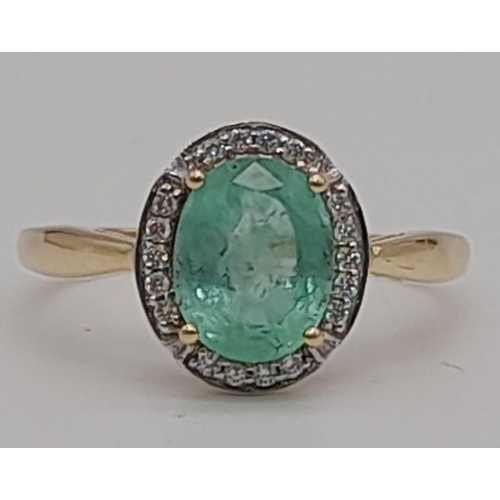 661 - A 14 K yellow gold ring with a Colombian, oval cut, emerald, surrounded by a halo of diamonds. Ring ... 