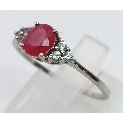 675 - A 9 K white gold ring with a central ruby and diamonds at the shoulders of the ring. Size: R, weight... 