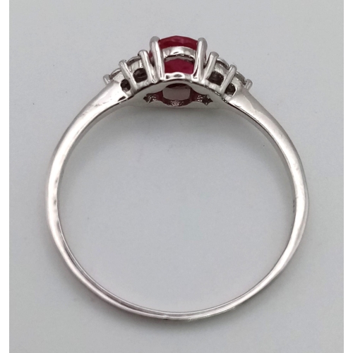 675 - A 9 K white gold ring with a central ruby and diamonds at the shoulders of the ring. Size: R, weight... 