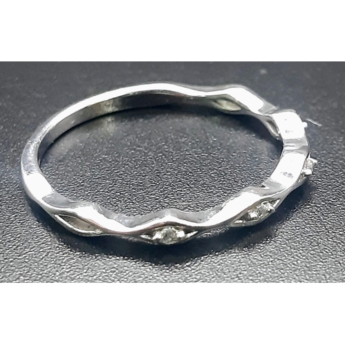 893 - A 9 K white gold diamond band ring. Size: L, weight: 1.2 g.