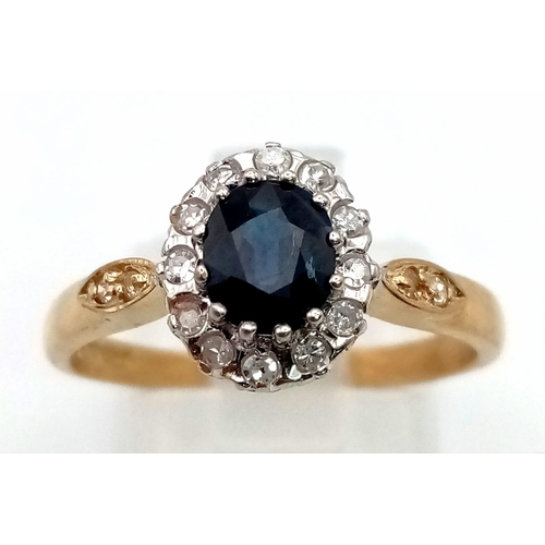 1055 - A 9K Yellow Gold Diamond and Sapphire Ring. Central clean oval sapphire surrounded by a halo of diam... 