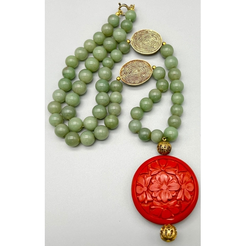 275 - An Antique Jade and Cinnabar Pendant Necklace. Pale green jade beads with floral oval cinnabar inter... 