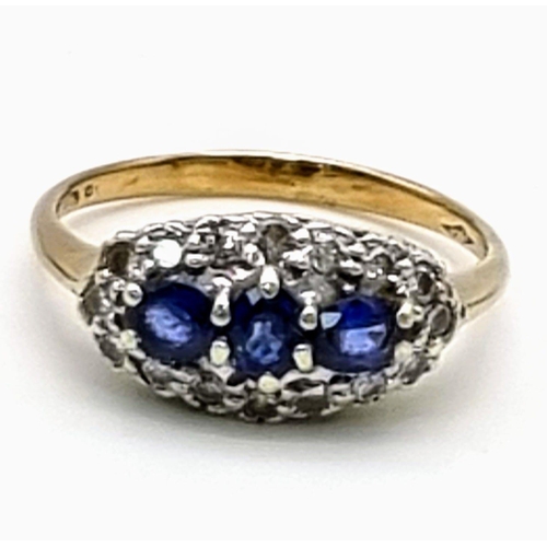 556 - A 9K Yellow Gold Sapphire and Diamond Ring. A trilogy of sapphires with a diamond surround. Size S. ... 