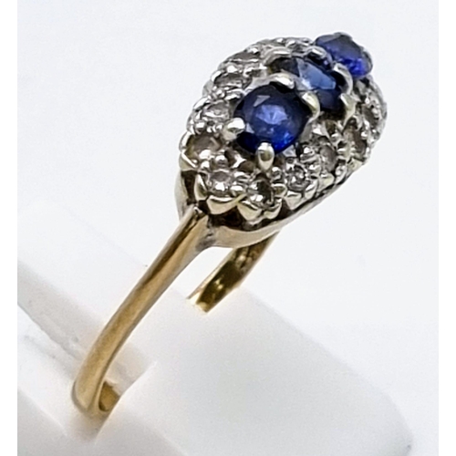 556 - A 9K Yellow Gold Sapphire and Diamond Ring. A trilogy of sapphires with a diamond surround. Size S. ... 