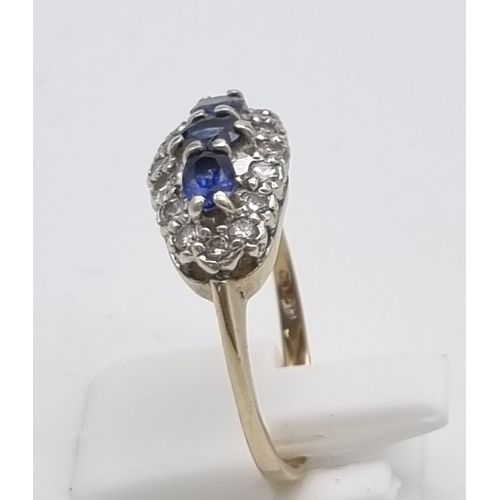 556 - A 9K Yellow Gold Sapphire and Diamond Ring. A trilogy of sapphires with a diamond surround. Size S. ... 