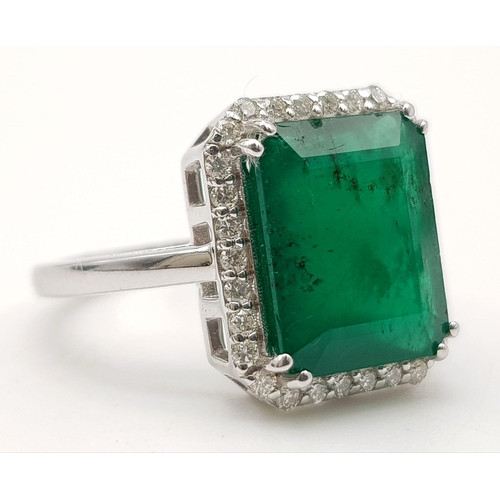 360 - A 14k White Gold Emerald and Diamond Ring. 5.5ct large central emerald surrounded with 1.1ct of Diam... 