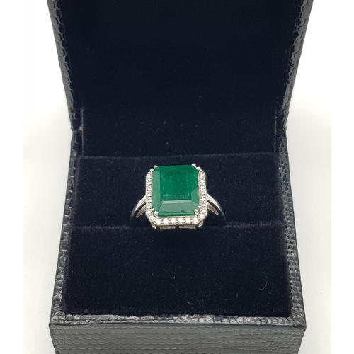 360 - A 14k White Gold Emerald and Diamond Ring. 5.5ct large central emerald surrounded with 1.1ct of Diam... 