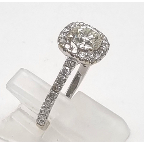 10 - An 18K White Gold Diamond Ring. A brilliant round-cut central diamond of 0.8ct surrounded by a halo ... 