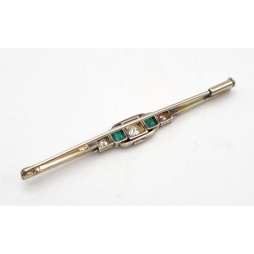 38 - A 14K White Gold Emerald and Diamond Bar Brooch. Central round cut diamond flanked by an emerald and... 