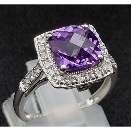 1500 - An Eye-Catching 9K White Gold Amethyst and Diamond Ring. Multi-faceted central clean amethyst surrou... 