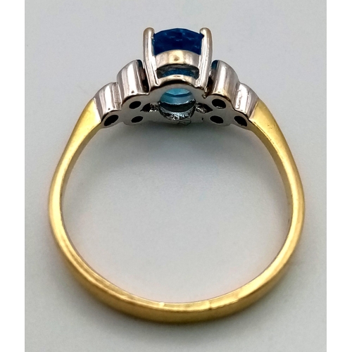 311 - An 18 K yellow gold ring with a beautiful London Blue, oval cut topaz and a trillion of diamonds on ... 