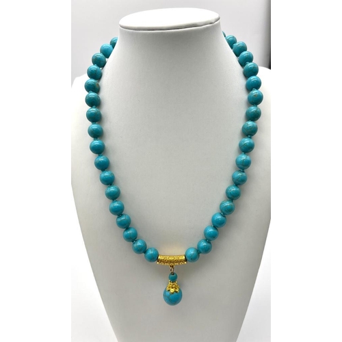 392 - A Blue Turquoise Beaded Necklace and Pendant. Gilded accents and clasp. 8mm beads. 42cm