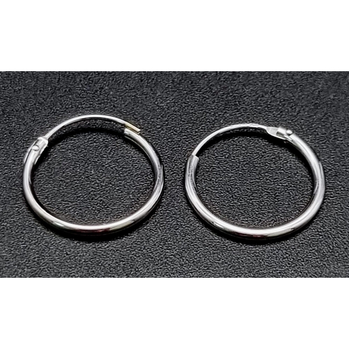 818 - A 9 K white gold pair of sleeper earrings. Weight: 0.3 g.